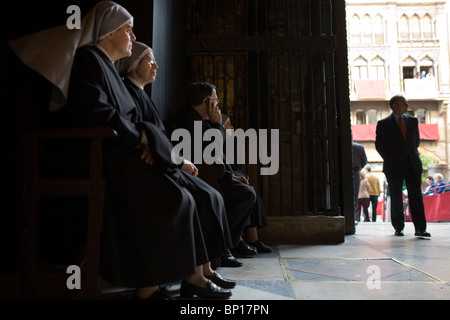 Le suore e un sacerdote all'interno della cattedrale di Siviglia, Spagna Foto Stock