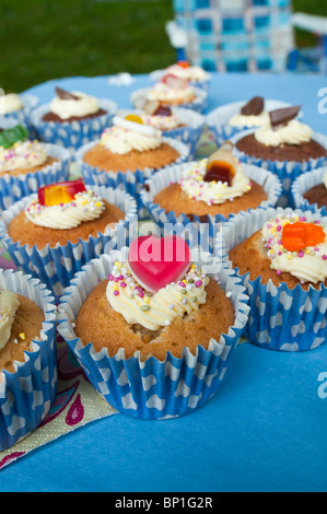 Iced muffin torte decorate alimentare spugna decorazione mini fata cuore stelle cioccolato glassa di turbolenza Foto Stock