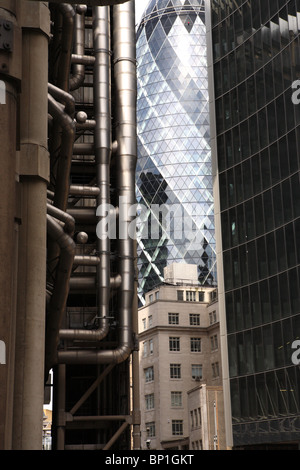 Una strada stretta vista con il Lloyds Building e il Gherkin, 30 St Mary Axe, dietro di esso nella City di Londra, London, EC3. Foto Stock