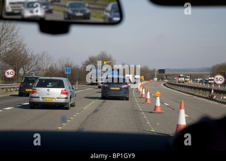 Motore modo opere stradali con traffico coni preso attraverso il parabrezza M5 England Regno Unito Foto Stock