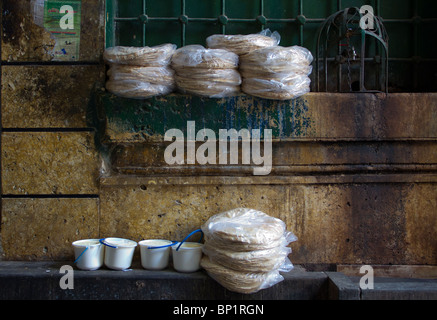 Cibi tradizionali nel souq antico mercato di Aleppo, Leban (yogurt) e pane piatto sedersi accanto al rubinetto di acqua Foto Stock