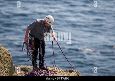 Un scalatore in piedi sulle rocce della costa di testa Gwennap in Cornovaglia. Foto Stock