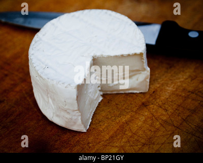 Poco tutto il formaggio di capra tagliata aperta per mostrare interno cremoso Foto Stock