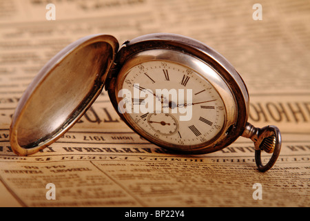 Argento antico orologio da tasca sul giornale vintage Foto Stock