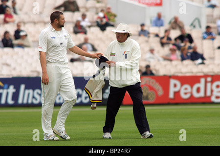 Steve Harmison mani il suo cappello e un maglione per l'arbitro prima di bowling per lo Yorkshire contro Lancashire a Old Trafford Foto Stock