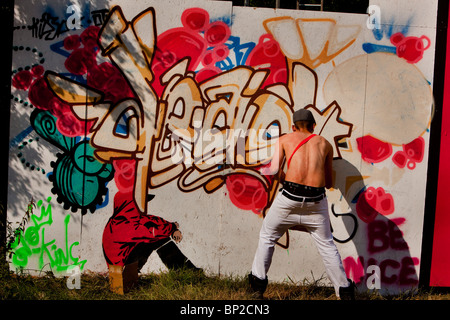 Un uomo di verniciatura di un graffiti presso il festival di Glastonbury, Somerste, REGNO UNITO Foto Stock