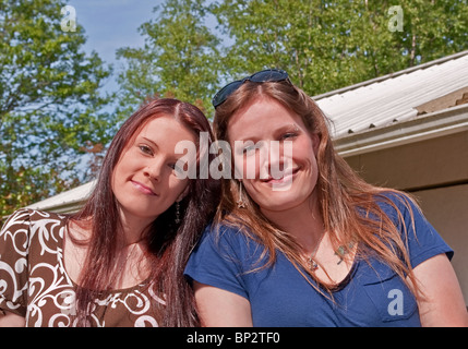 Questo stock photo sono due giovani adulti Caucasian brunette le donne sia con i capelli lunghi e sorridente che sono entrambe le sorelle e gli amici. Foto Stock