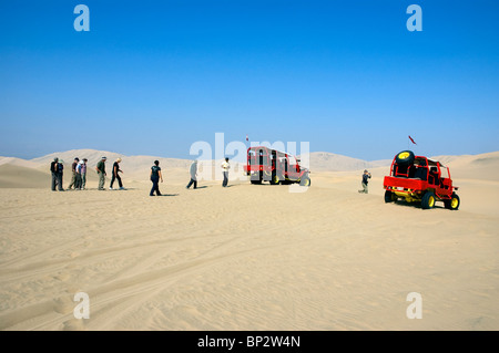 Dune Buggy con turisti sand boarding sulle vaste dune di sabbia del deserto vicino la Huacachina Oasis, Ica, Perù. Foto Stock