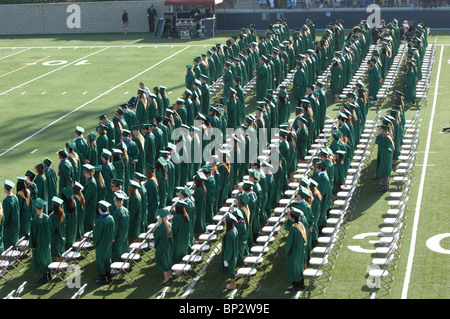 I laureati line up e supporto durante la graduazione cerimonia di inizio. Foto Stock