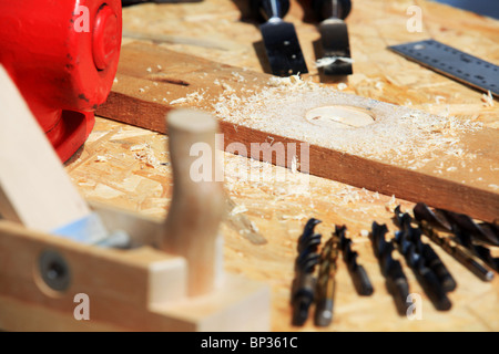 Attrezzi di falegnameria su un banco di lavoro superficie con trucioli di legno Foto Stock