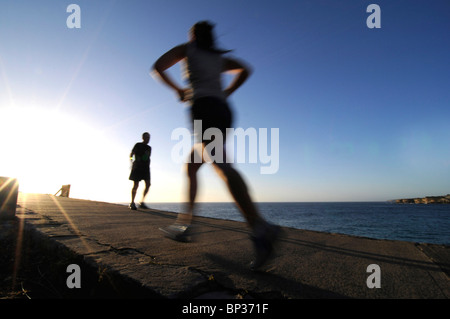 Women jogging in the early morning on the coastal track near Bondi in Sydney's eastern suburbs, Australia. Foto Stock
