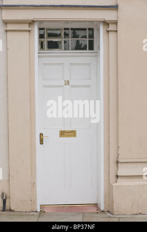 Dipinto di bianco con pannelli in legno porta anteriore n. 18 con maniglia in ottone letterbox e ritaglio del periodo town house nel Regno Unito Foto Stock