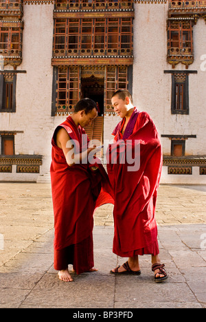 I monaci buddisti a giocare con i loro nuovi telefoni cellulari, Thimpu Dzong, Bhutan, non modello rilasciato Foto Stock