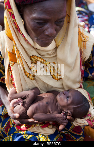 GUIDAN IDER Village, vicino KONNI, NIGER, 27LUGLIO 2010: Ayi Mohamed, 40, basi il suo 3 mese vecchio grand-figlia Bourja Gada Foto Stock