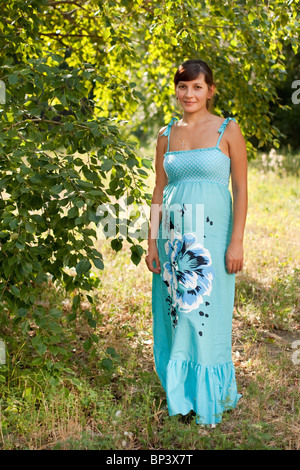 Outdoor ritratto di bella donna incinta in un sarafan blu Foto Stock