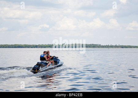 Lake George, FL - Maggio 2010 - uomo si siede dietro donna alla guida di una moto d'acqua sul lago George nella Florida Centrale Foto Stock