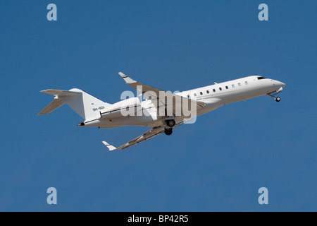 Bombardier Global Express XRS jet privato gestito da Comlux Aviation Malta, mostrato in fase di decollo contro un cielo blu chiaro Foto Stock