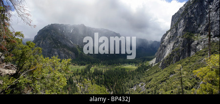 Una vista panoramica attraverso il Parco Nazionale di Yosemite con nuvole di neve in arrivo sulle montagne. Foto Stock