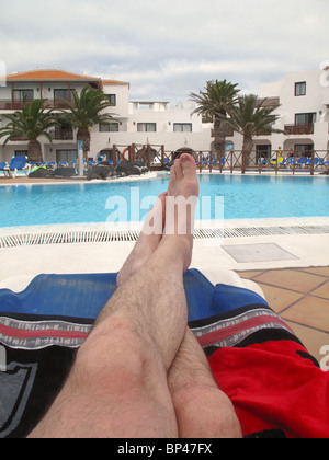 Mans piedi sui lettini in piscina Foto Stock