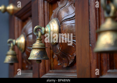 Singapore. Le campane di bronzo decorare il cancello principale del Tempio di Sri Mariamman Foto Stock