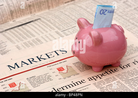 Rosa salvadanaio con 20 euro nota seduto su una copia del Financial Times money markets sezione nel Regno Unito Foto Stock