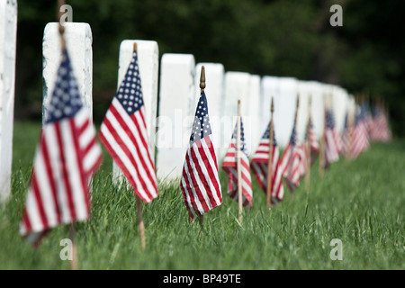 Una bandiera americana linee ogni lapide a ricordo dei soldati caduti in battaglia del Memorial Day in Arlington National Cemeter Foto Stock
