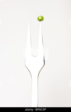 Immagine astratta di pisello unico sul concetto di forche isolata contro il bianco. Foto Stock