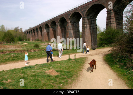 Regno Unito, Inghilterra, Cheshire, Stockport, rossastro Vale, Country Park, famiglia passeggiate con il cane sul tracciato sotto il viadotto ferroviario Foto Stock