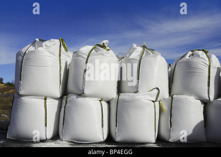 Sale sacchi bianco righe impilate per evitare strade di ghiaccio asfalto Foto Stock