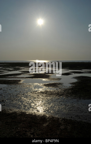 Tramonto sulla spiaggia a Hunstanton con figure distanti, Norfolk. Foto Stock