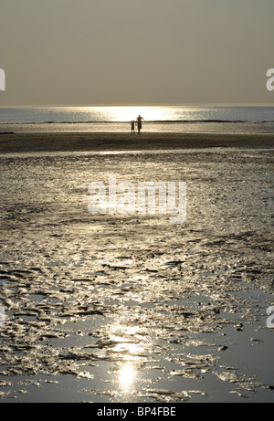 Tramonto sulla spiaggia a Hunstanton con figure distanti, Norfolk. Foto Stock