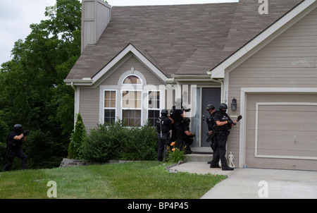 La polizia Tactical team da strada Unità narcotici approccio residence a servire un farmaco relative ad alto rischio di un mandato di perquisizione. KC MO/Pd. Foto Stock