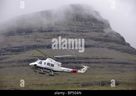Atlantic Airways elicottero arrivando a Svínoy, Isole Faerøer Foto Stock