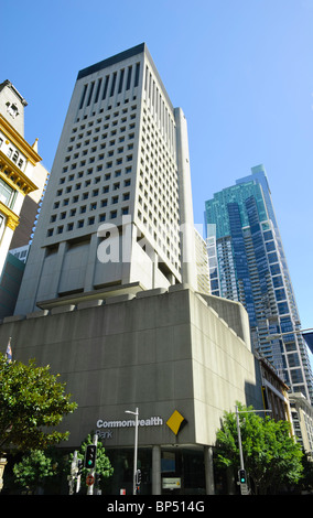 Un alto brutalist skscraper contenente sedi bancarie con altri edifici alti dietro Foto Stock