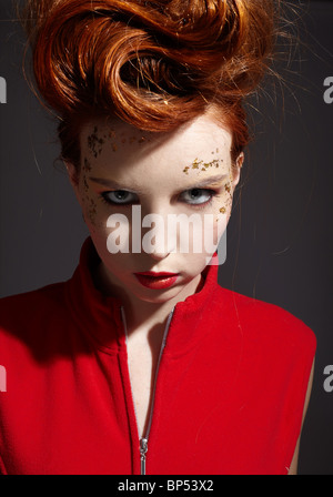 Ritratto di bella ragazza redhead che pongono in giacca rossa Foto Stock