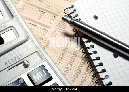 Calcolatrice finanziaria, acciaio penna e posa di notebook sul giornale. Concetto. Foto Stock