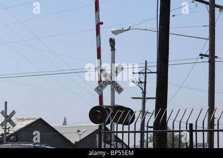 Ferrovia Strada attraversando luci, pali del telefono e del cablaggio di overhead. Foto Stock