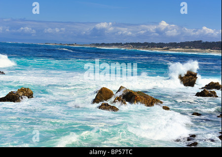 Il turchese e il blu delle onde che si infrangono sulla battigia e spruzzi contro le rocce, punto Joe, Pebble Beach California lungo la 17 Mile Drive Foto Stock