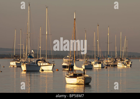 Barche ormeggiate al tramonto nel porto Foto Stock