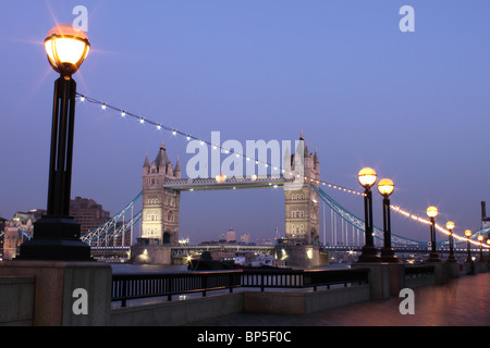 Il Tower Bridge al tramonto dalla banca del sud, con terrapieno luci in primo piano e le luci sul ponte di Londra, Inghilterra, Regno Unito Foto Stock