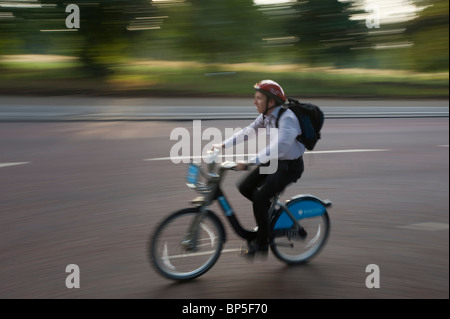 Commuter in Londra viaggi attraverso Hyde Park utilizzando uno dei Ciclo schema di noleggio biciclette introdotta a Londra nel 2010 Foto Stock