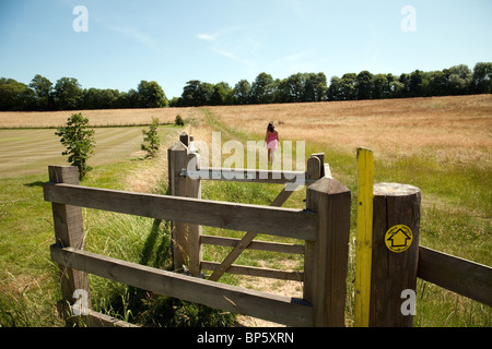 Una giovane donna che cammina nella campagna britannica, Lyminge village vicino a Folkestone, Kent, Regno Unito Foto Stock