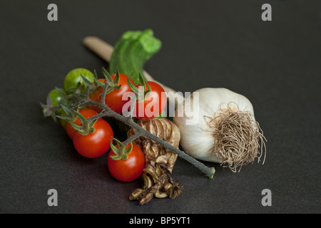 Una selezione di fresco giardino organici vegetali tra cui aglio la zucchina e pomodoro Foto Stock