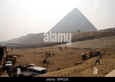 Vista della Piramide di Giza prese nei confronti di un inizio di mattina di Sun con i turisti cavalli e cammelli davanti Foto Stock