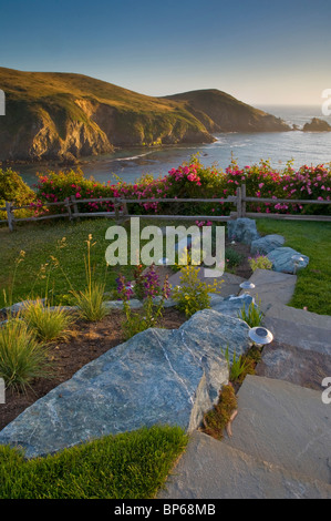 Prato e giardino che affacciano sull'oceano al tramonto, Albion fiume Inn, Albion, Mendocino County, California Foto Stock