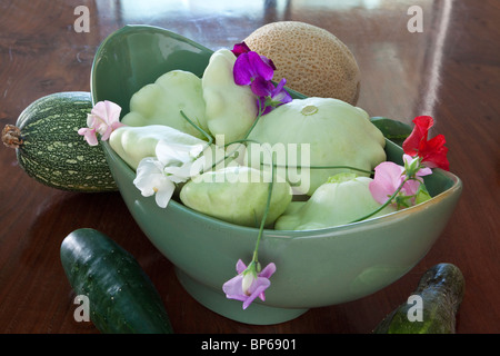 Patty Pan Squash con piselli dolci in una ciotola verde Foto Stock