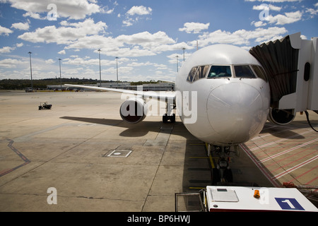 Un aereo collegato ad un passeggero ponte di imbarco Foto Stock