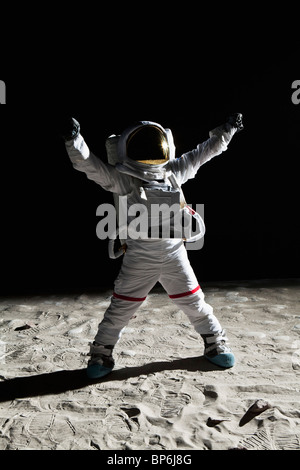 Un astronauta sulla luna con le braccia alzate in segno di vittoria Foto Stock