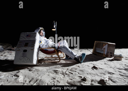 Un astronauta sulla luna di guardare la televisione Foto Stock