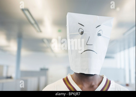 Imprenditore indossando un sacco di carta di una faccina triste Foto Stock